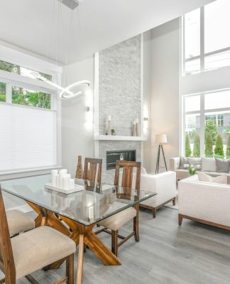 jasny salon, stół z drewnianymi krzesłami w centrum