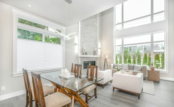 jasny salon, stół z drewnianymi krzesłami w centrum