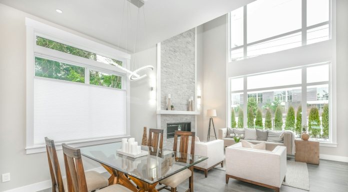 jasny salon, stół z drewnianymi krzesłami w centrum