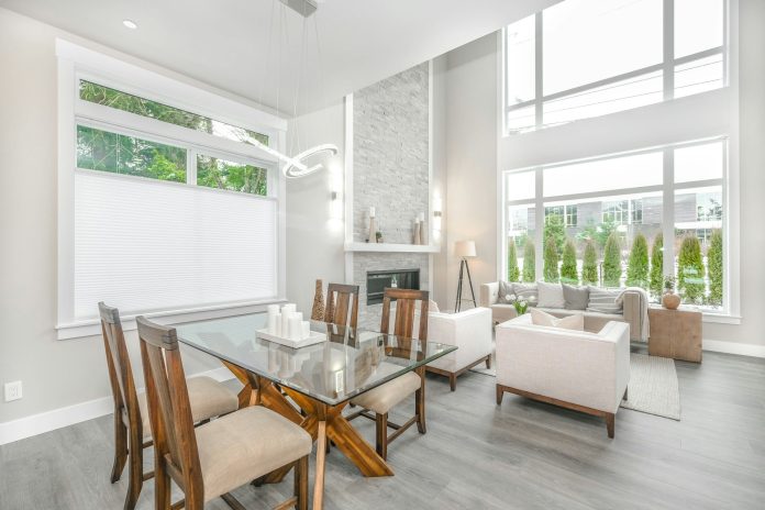 jasny salon, stół z drewnianymi krzesłami w centrum